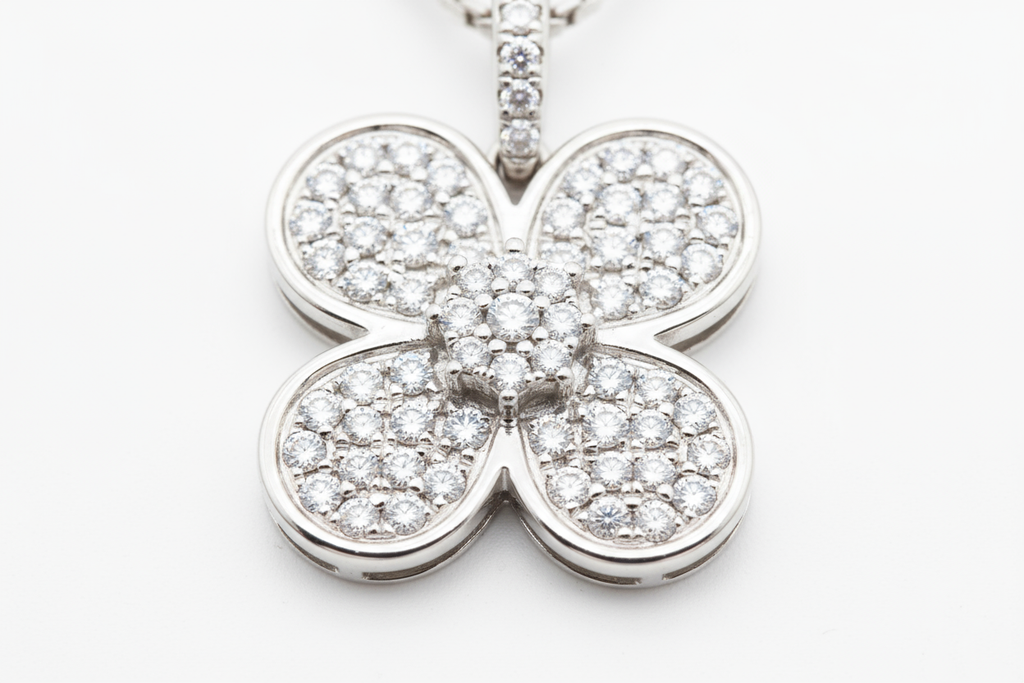 zoomed in picture of a diamond plated 4-clove pendant on a white background